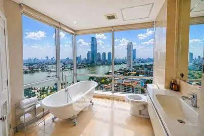 Luxurious bathroom with stunning city skyline and river view, featuring a freestanding bathtub and modern fixtures.