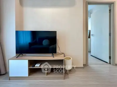 Modern living room with sleek TV stand and open doorway, showcasing minimalist design and neutral tones.