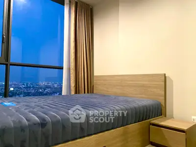 Modern bedroom with city view, featuring a cozy bed and elegant curtains.