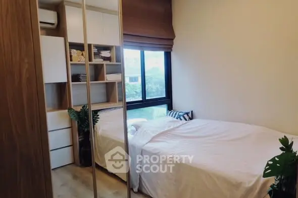 Cozy bedroom with large window and built-in storage, perfect for modern living.