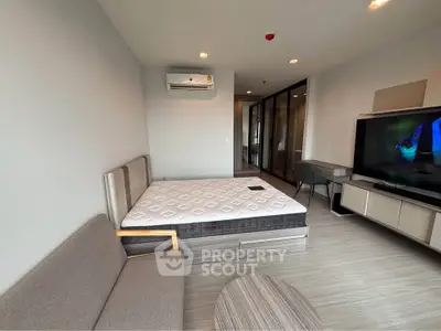 Modern bedroom with stylish furniture and large TV in a contemporary apartment.
