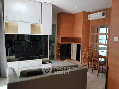 Modern living room with sleek furniture and dining area in open layout apartment.