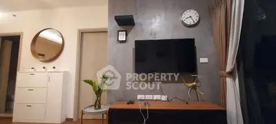Modern living room with wall-mounted TV, stylish decor, and natural lighting.