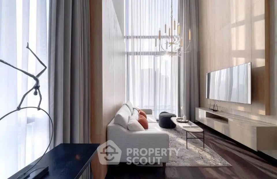 Luxurious modern living room with high ceilings, elegant chandelier, and large windows for natural light.