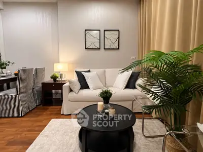 Elegant living room with modern decor, cozy sofa, stylish dining area, and lush indoor plant for a welcoming ambiance.