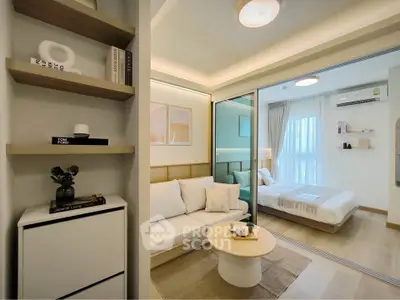 Modern studio apartment with cozy living area and bedroom separated by glass wall.