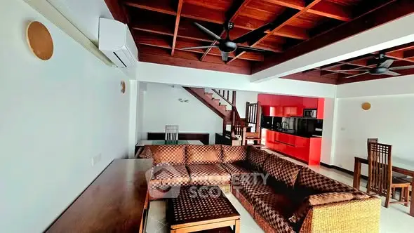 Spacious living room with wooden ceiling and modern furniture in a stylish home.