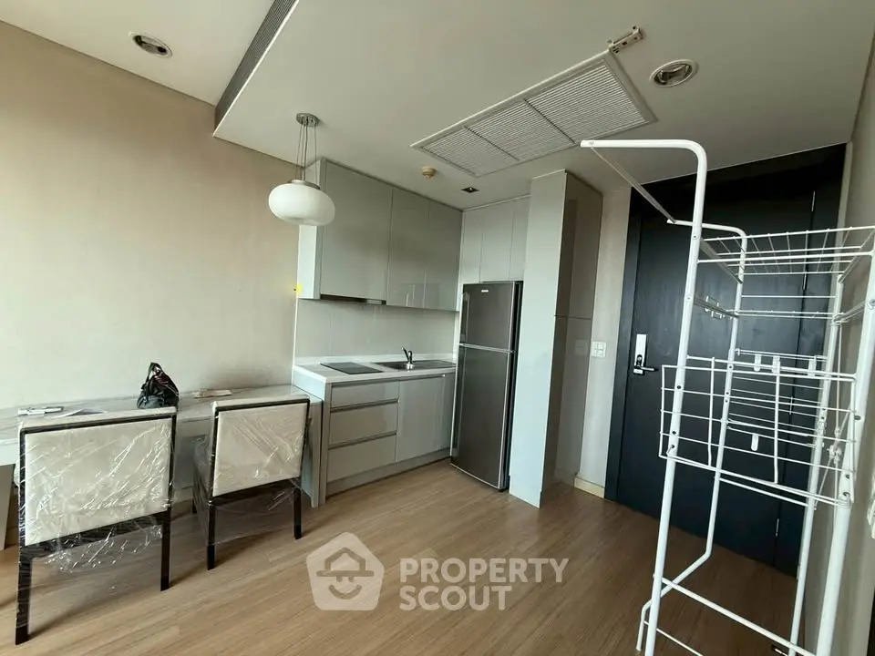 Modern kitchen with dining area and sleek appliances in a stylish apartment.