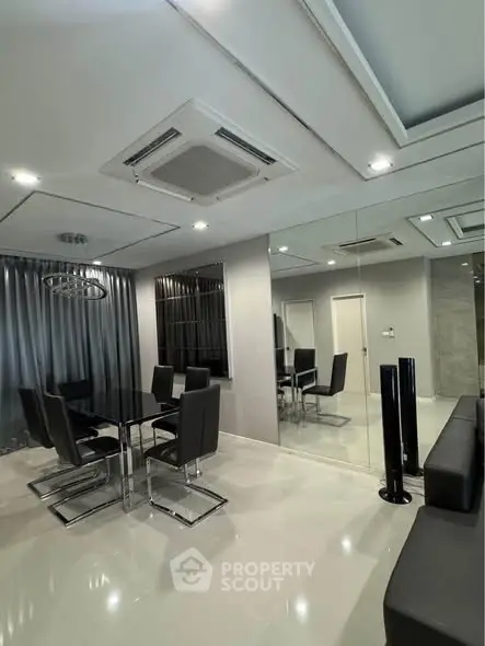 Modern dining room with sleek black furniture and mirrored wall