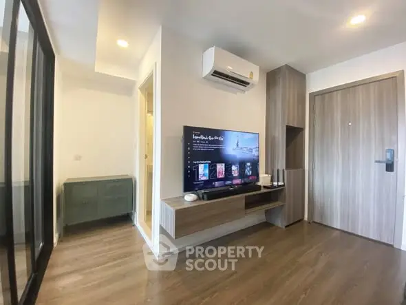 Modern living room with sleek wooden flooring, wall-mounted TV, and stylish air conditioning unit.