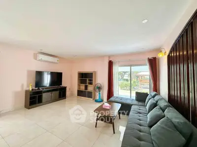 Spacious living room with modern furniture and large window view.