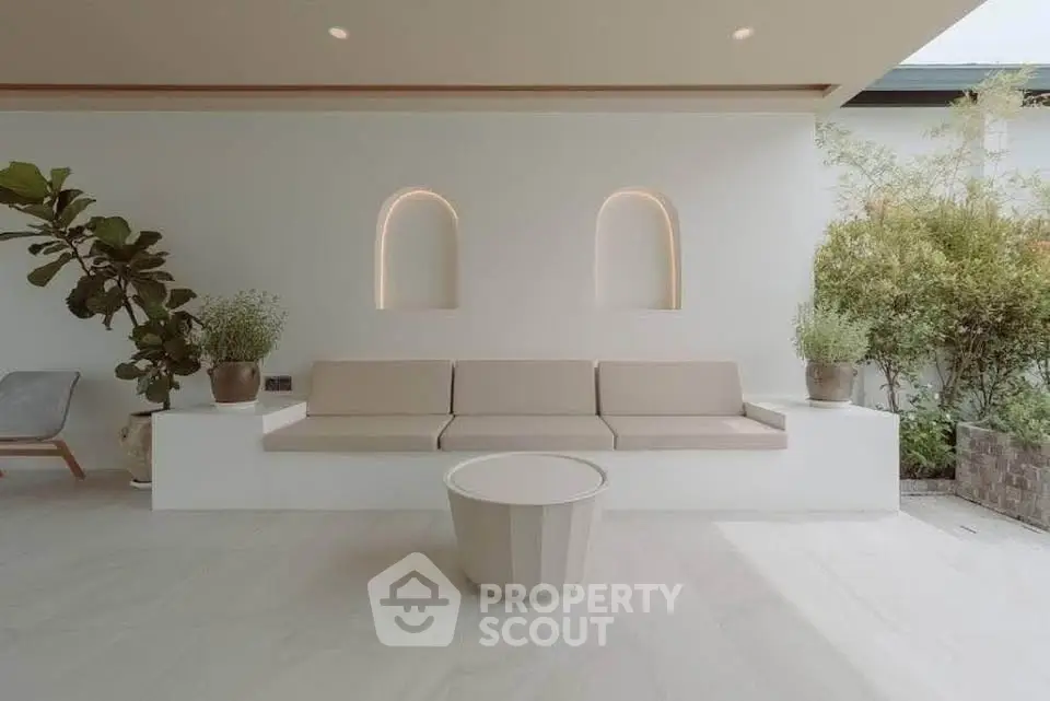 Elegant outdoor seating area with modern design and lush greenery, perfect for relaxation and entertaining.