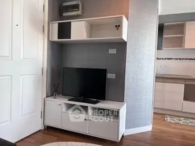 Modern living room with sleek TV stand and stylish shelving in a cozy apartment.