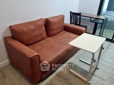 Cozy living room with brown leather sofa and modern table, perfect for relaxation.