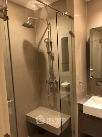 Modern bathroom with glass shower and sleek fixtures in a contemporary apartment.