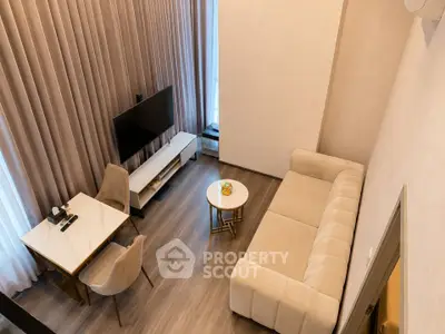 Modern living room with elegant furniture and high ceilings, featuring a cozy sofa and sleek TV setup.