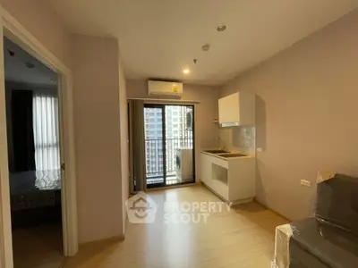 Modern apartment interior with compact kitchen and balcony view