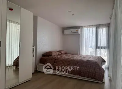 Modern bedroom with large window and air conditioning in urban apartment