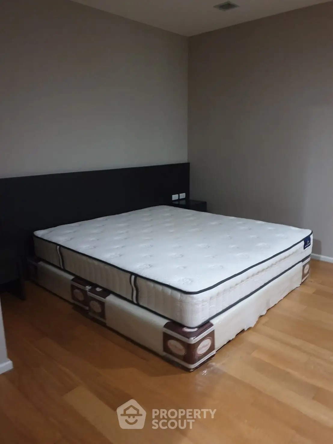 Spacious bedroom with a large comfortable mattress on wooden flooring