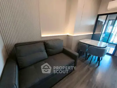 Modern living room with stylish sofa and dining area, featuring sleek design and ambient lighting.