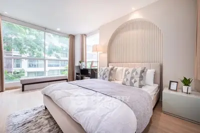Luxurious bedroom with large windows and modern decor in a stylish apartment.