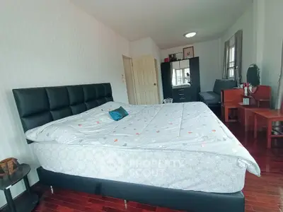 Spacious bedroom with modern furniture and wooden flooring