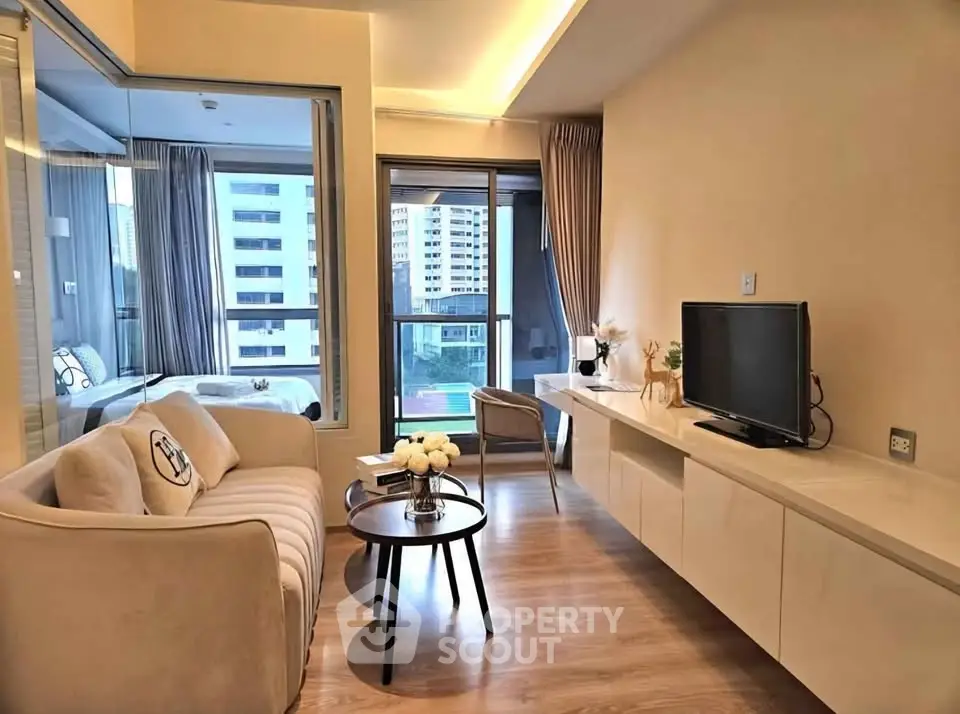 Modern living room with elegant decor and city view, featuring a cozy sofa and sleek entertainment unit.