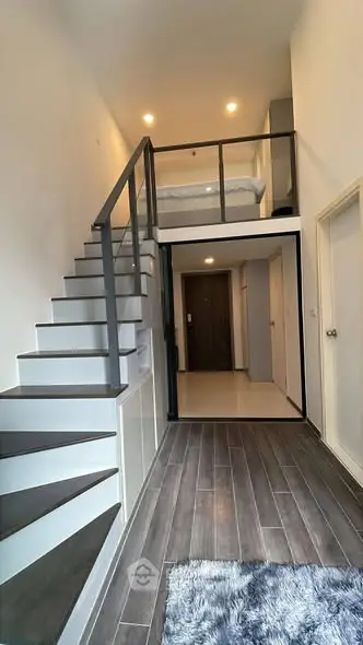 Modern loft apartment with stylish staircase and cozy mezzanine bedroom.
