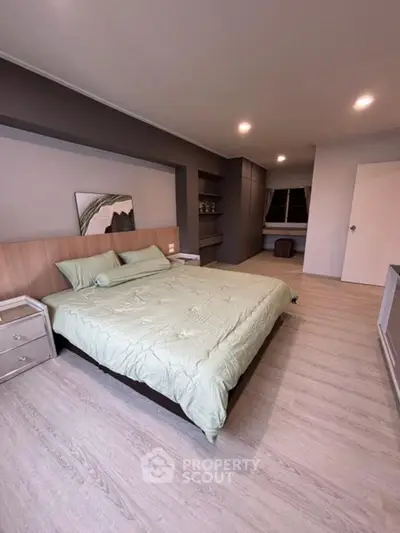Spacious modern bedroom with stylish decor and ample natural light.