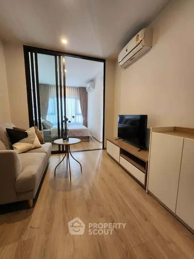 Modern living room with sleek design and cozy ambiance, featuring a stylish sofa and flat-screen TV.