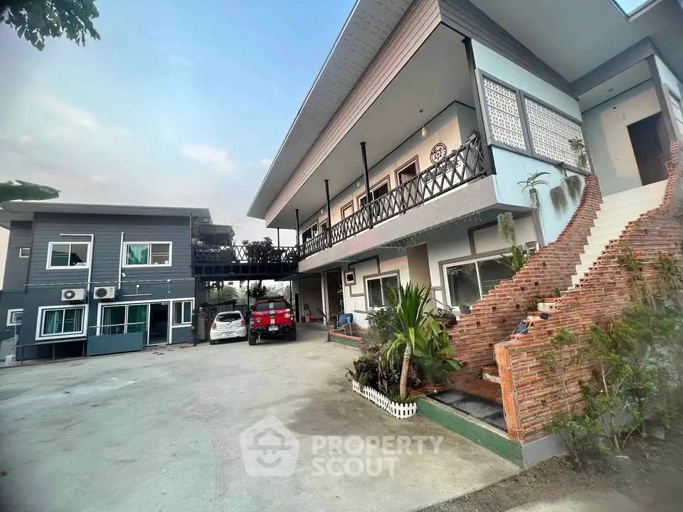 Modern two-story house with spacious driveway and unique brick staircase.