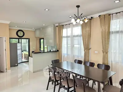 Spacious dining area with elegant chandelier and modern kitchen in open layout