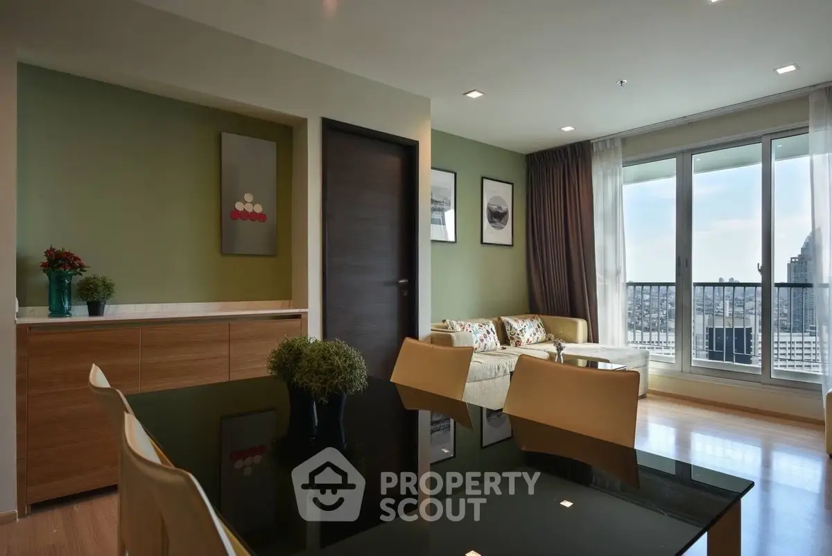 Modern living room with large windows and city view, featuring stylish decor and comfortable seating.