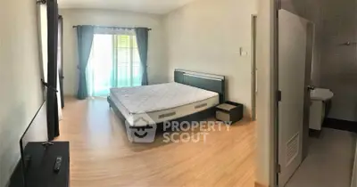 Spacious bedroom with natural light and modern furnishings