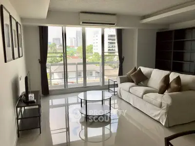 Spacious living room with modern decor and large windows offering a city view.