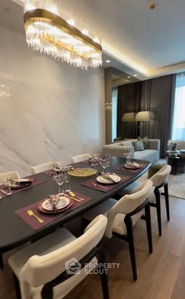 Luxurious dining area with elegant chandelier and modern decor in upscale apartment.