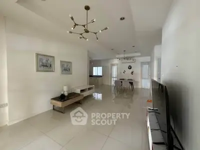 Spacious modern living room with elegant lighting and sleek furniture, perfect for contemporary living.