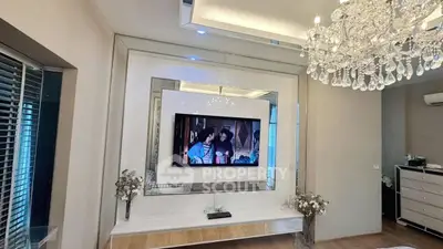 Luxurious living room with chandelier and modern TV setup