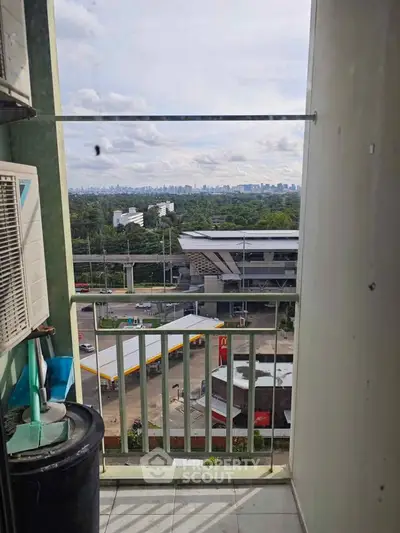 Urban balcony with city view, showcasing nearby amenities and skyline in the distance.