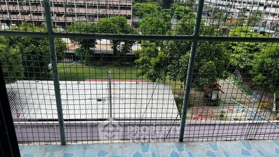 Scenic view from balcony overlooking lush garden and playground, perfect for family living.