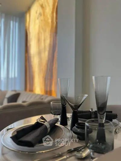 Elegant dining setup with modern glassware and stylish table setting in a luxurious apartment.