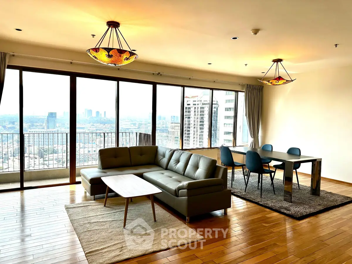 Spacious living room with city view, modern furniture, and elegant lighting in a high-rise apartment.