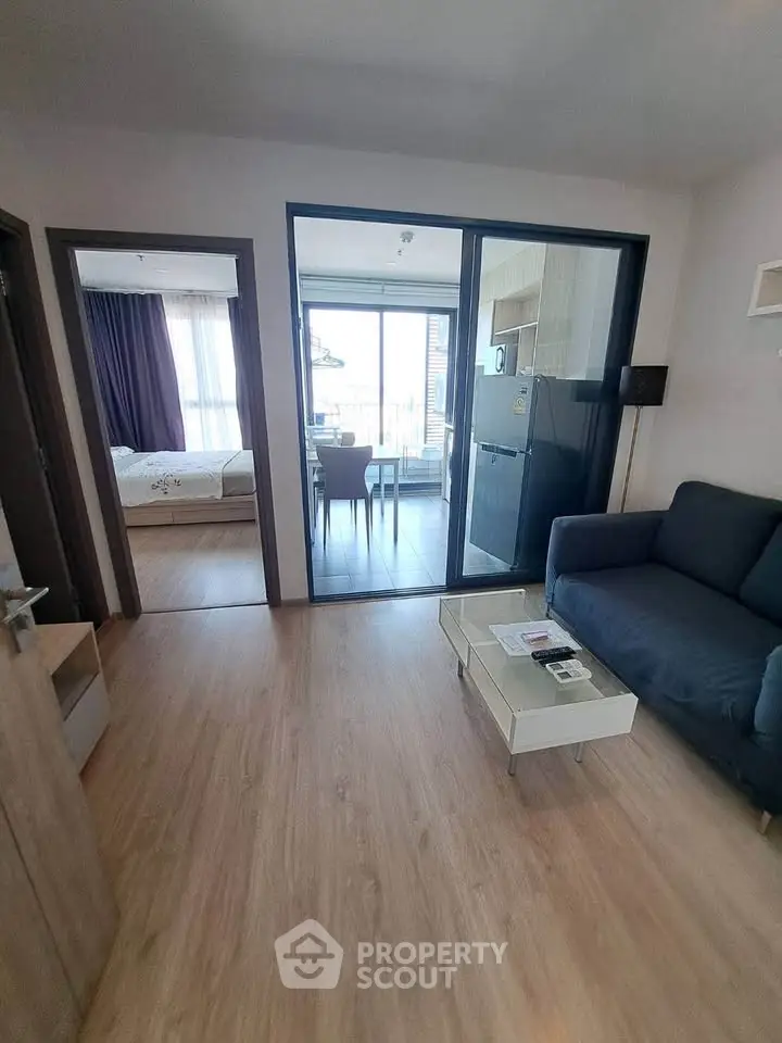 Modern apartment interior with open layout, featuring a cozy living room and dining area with natural light.