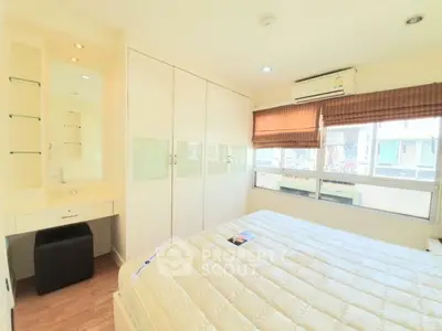 Bright and cozy bedroom with large windows and built-in wardrobe