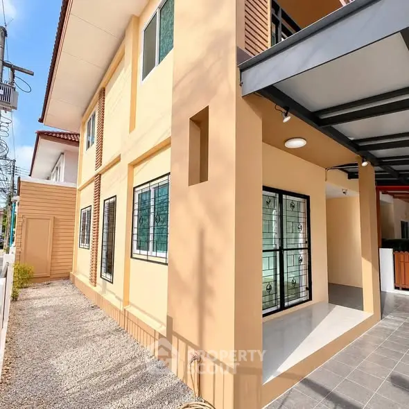 Modern two-story house with beige exterior and covered entrance