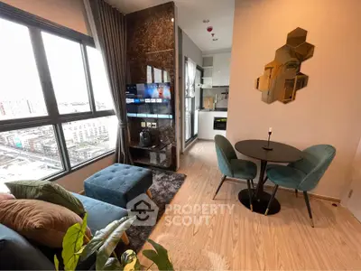 Modern living room with city view, stylish furniture, and open kitchen layout.