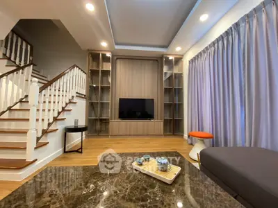 Spacious modern living room with elegant staircase and built-in TV unit