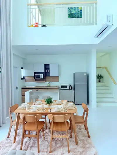 Modern open-plan kitchen and dining area with stylish furniture and bright natural lighting.