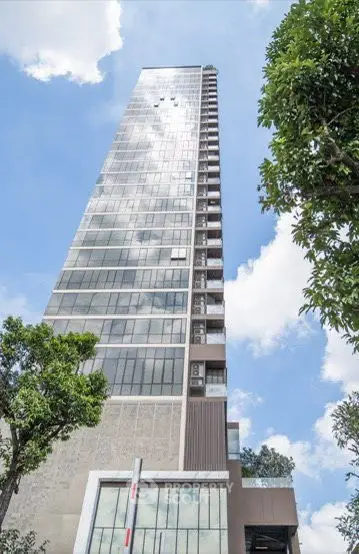 Modern architectural building with sleek glass facade and lush greenery