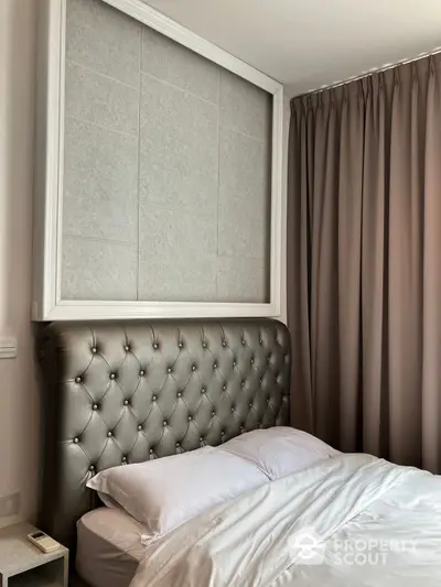 Elegant bedroom with a luxurious tufted headboard and sophisticated neutral color palette, complemented by plush curtains and crisp white bedding.